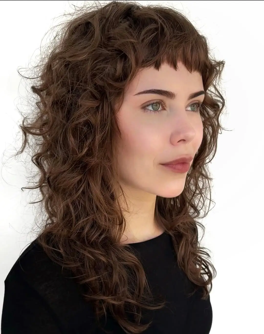 chic summer haircut 2026 Curly shag with soft boho fringe energy