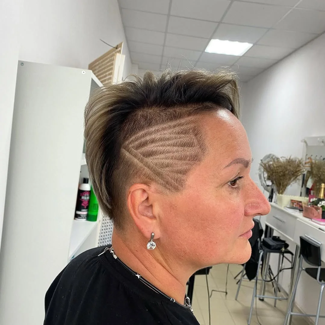 flattering summer haircuts for women over 50 2026 Edgy Undercut Pixie with Graphic Detail
