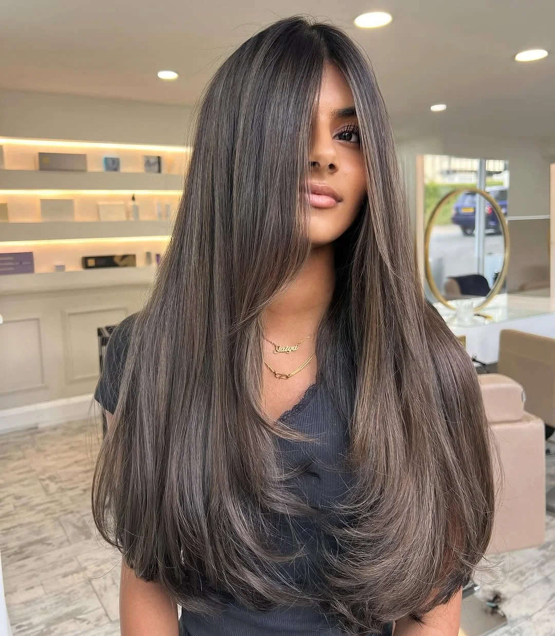 smoky summer ash brown hair color 2026 Sleek cool ash layers with face framing flow
