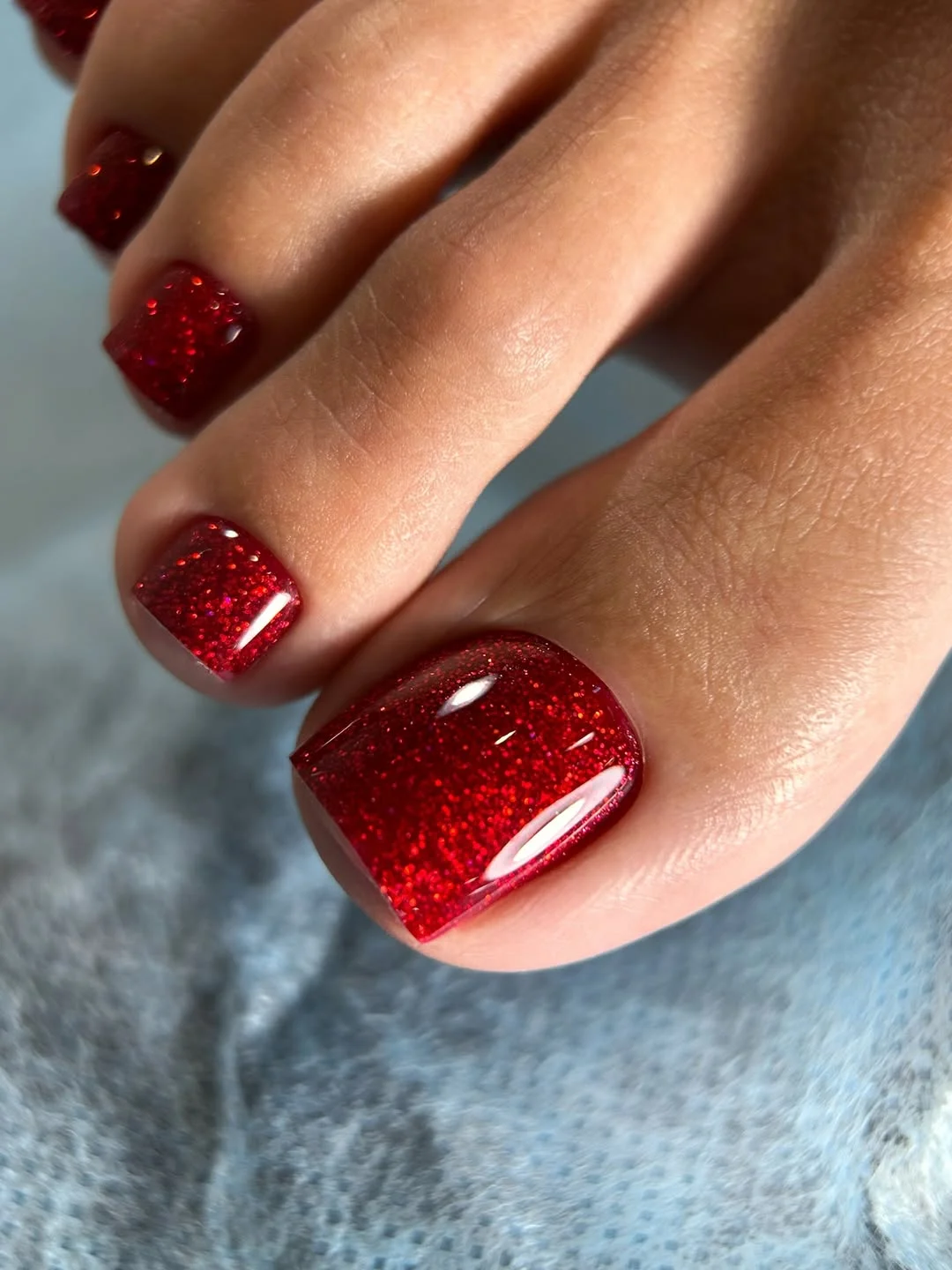 summer toe nails colors 2026 Ruby Red Glitter Pedicure for Bold Summer Looks