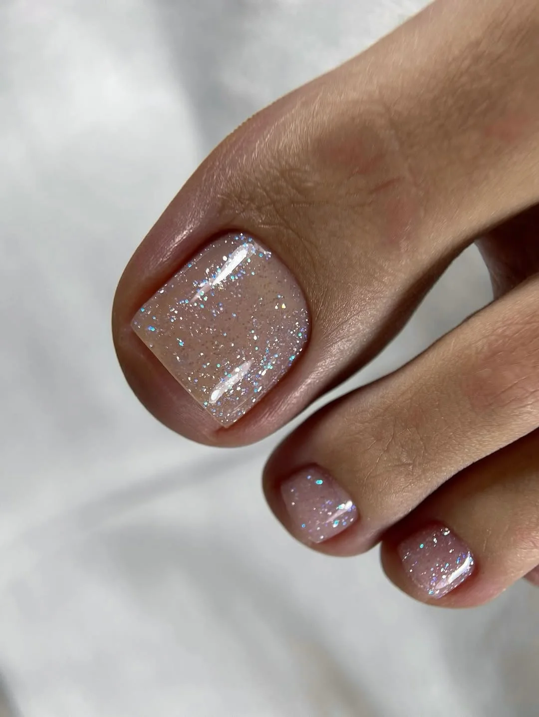 summer toe nails colors 2026 Soft Milky Glitter Pedicure for Minimalist Style