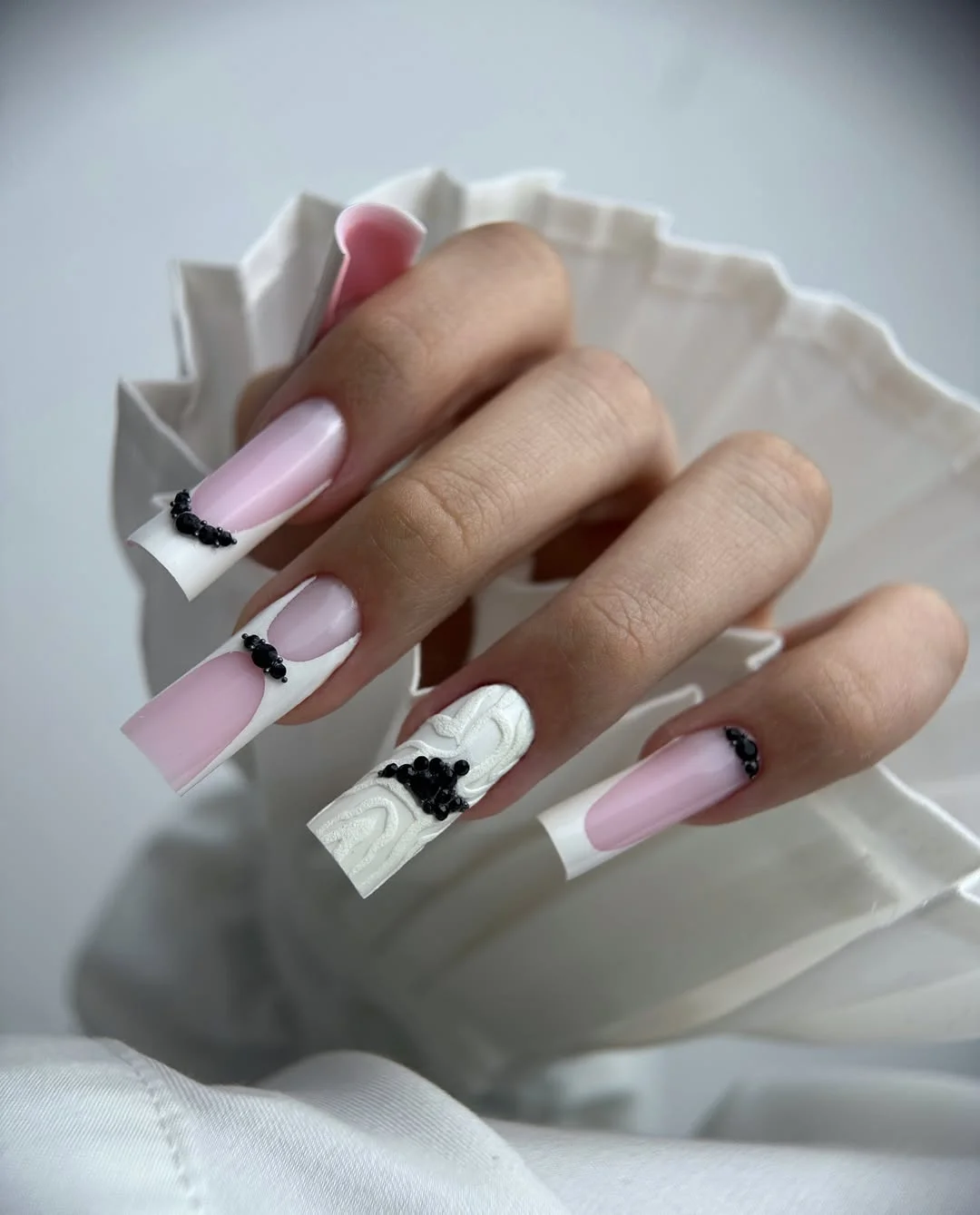 pretty july nails design ideas 2026 Soft Pink French Nails with Black Crystal Accents