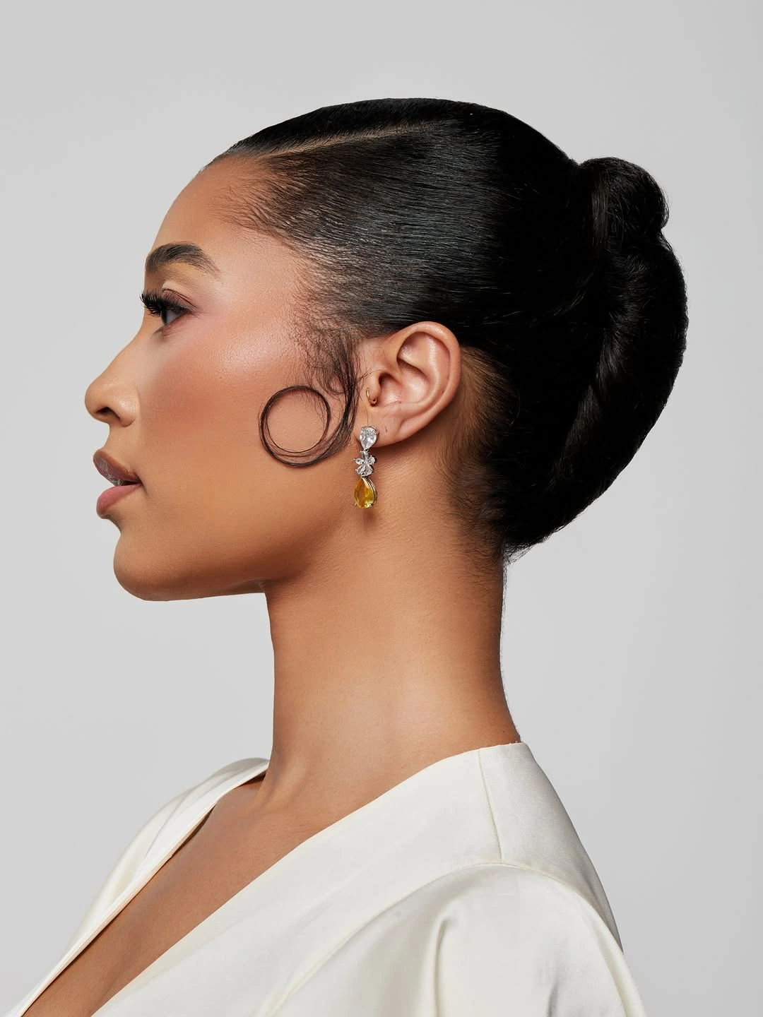 beautiful september hairstyles ideas 2026 Sleek Low Bun with a Graphic Curl