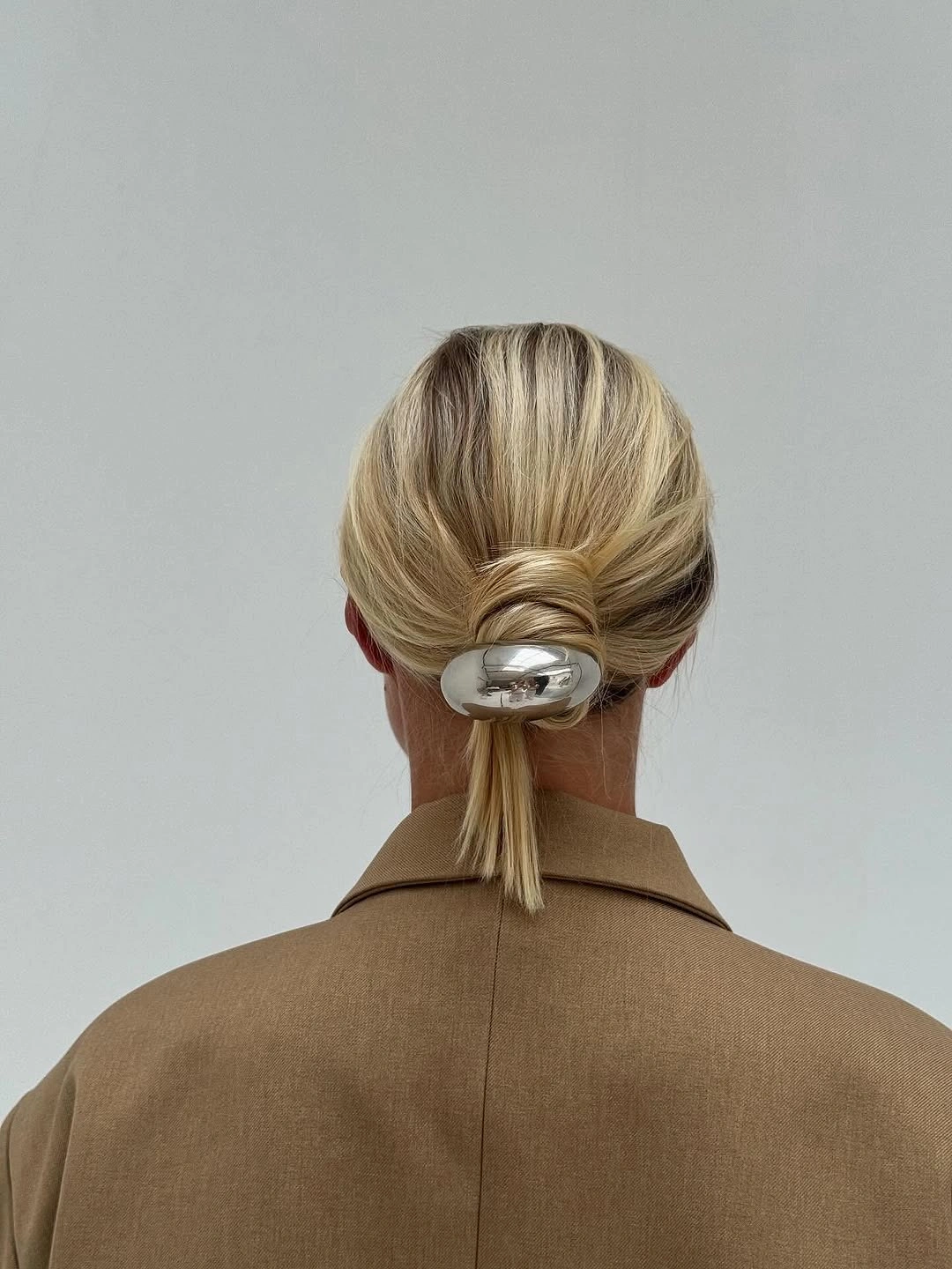 fall hairstyles for short hair 2026 Sculptural Low Twist With a Modern Metal Accent