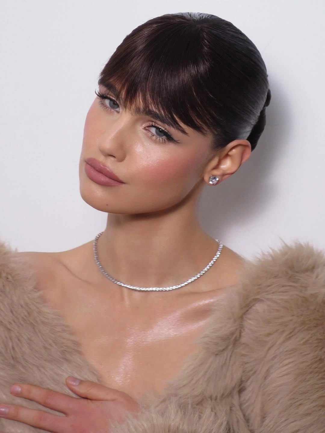 fall hairstyles for wedding guests 2026 Sleek Updo With Soft Fringe