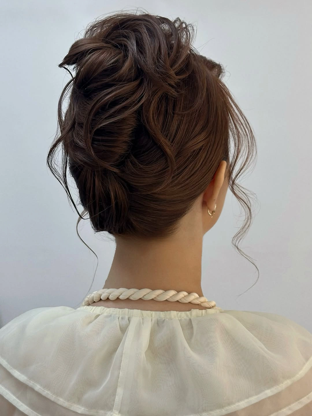 fall hairstyles for wedding guests 2026 Textured Low Updo With Soft Face-Framing Pieces