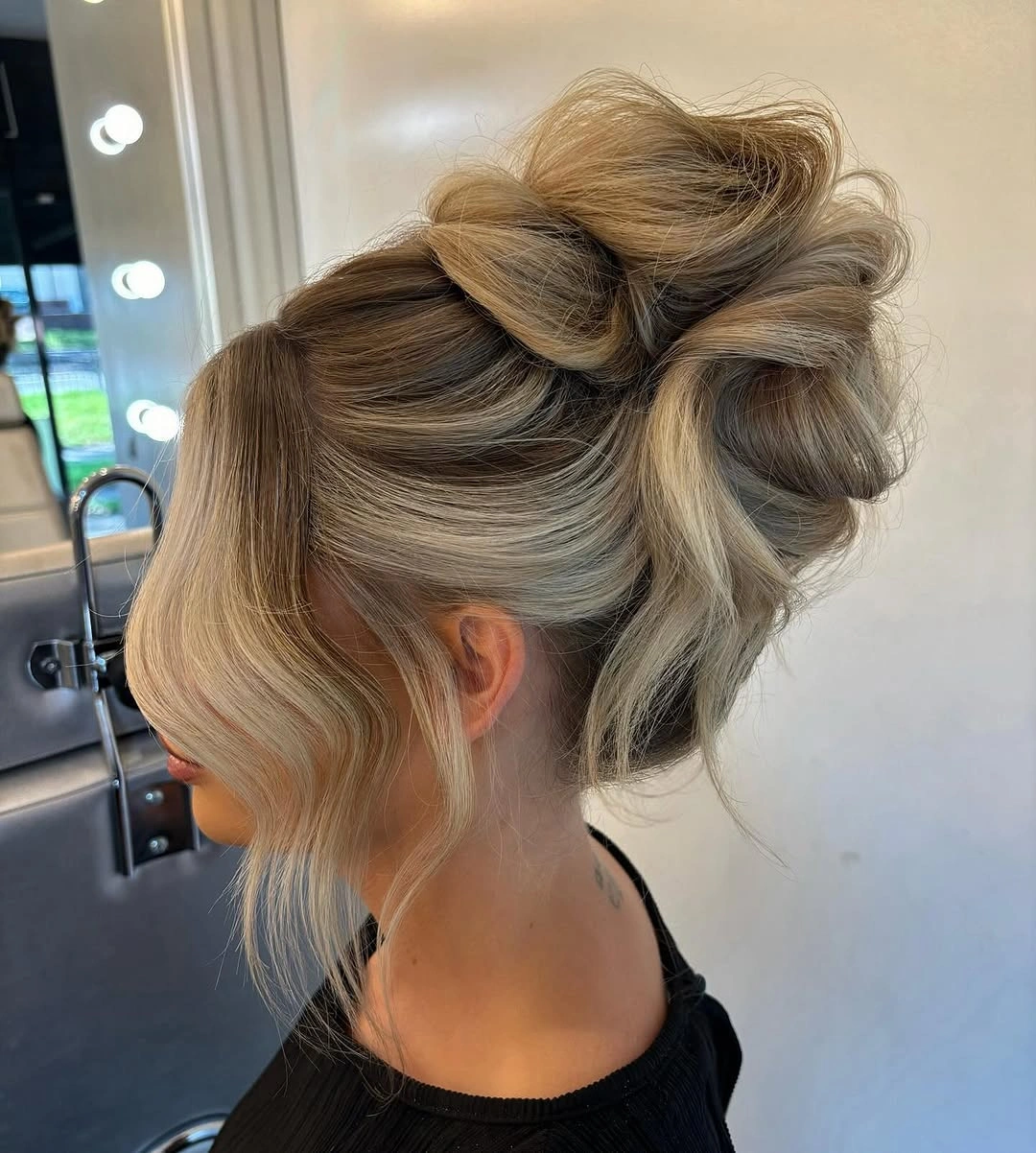 stylish bridesmaid hairstyling Soft Textured Bun with Face-Framing Layers