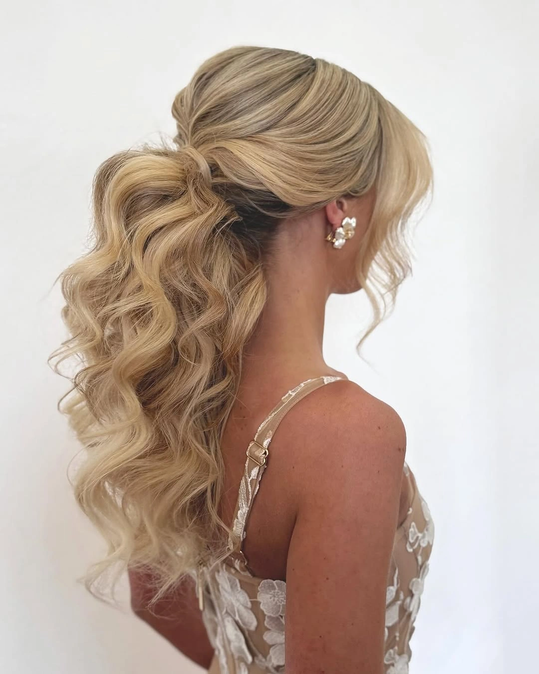stylish bridesmaid hairstyling Voluminous Low Ponytail with Soft Romantic Curls