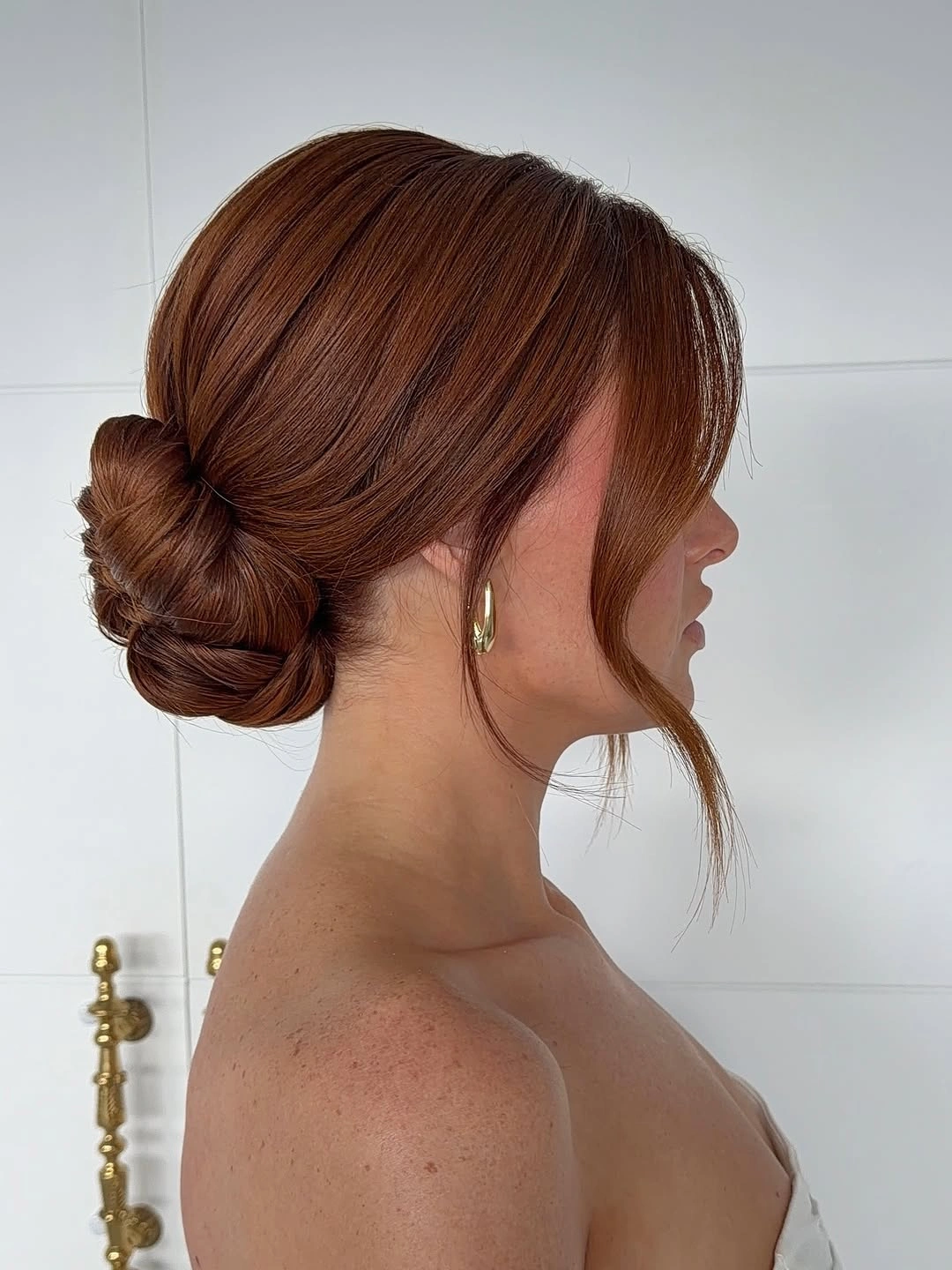 stylish bridesmaid hairstyling Minimalist Low Bun with Soft Face-Framing Bangs