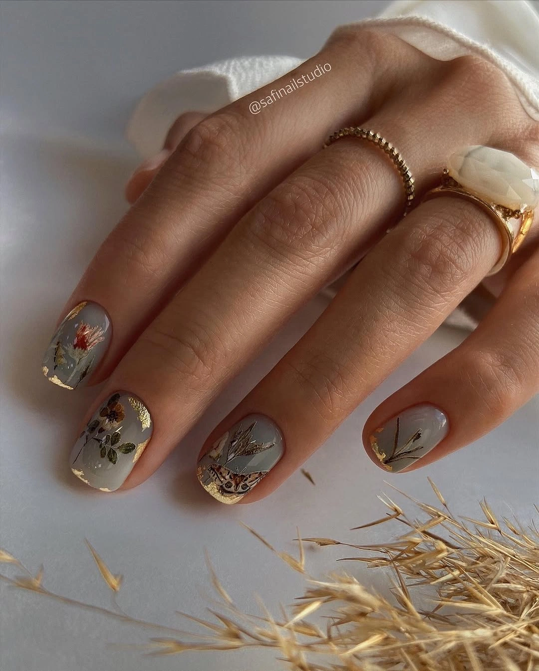trendy fall short nails 2026 Muted Botanical Nails With Gold Leaf Details
