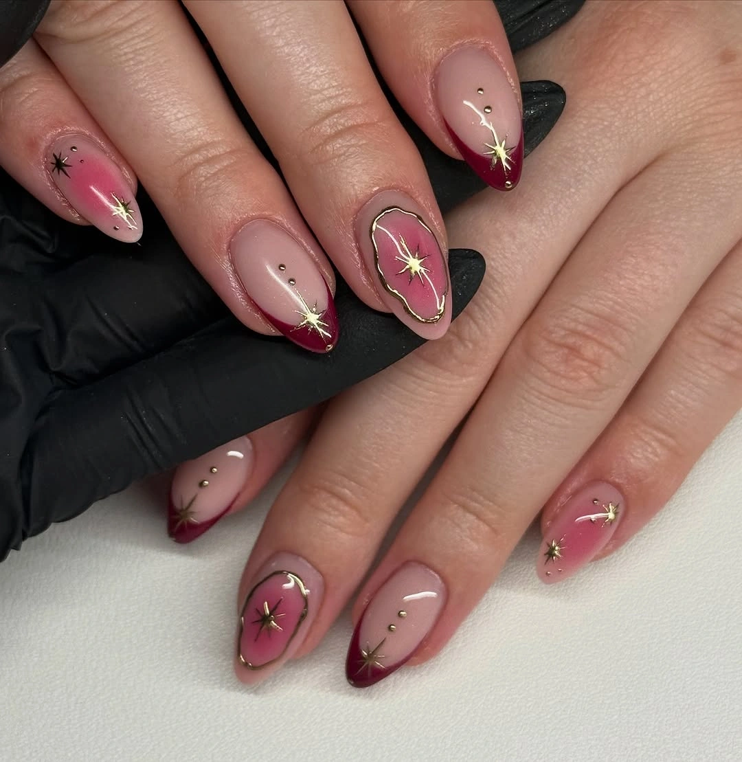 chic fall burgundy nails with design - Burgundy French Tips With Gold Starburst Details