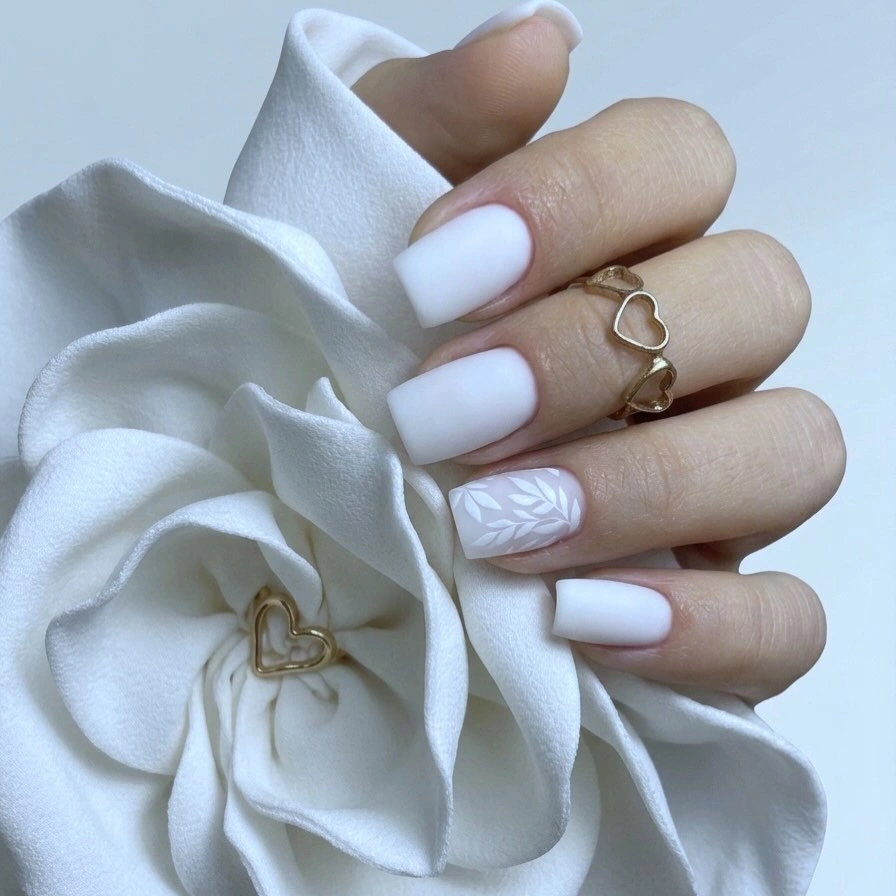 chic fall nails for pale skin 2026 Cloud White Nails with a Delicate Leaf Accent