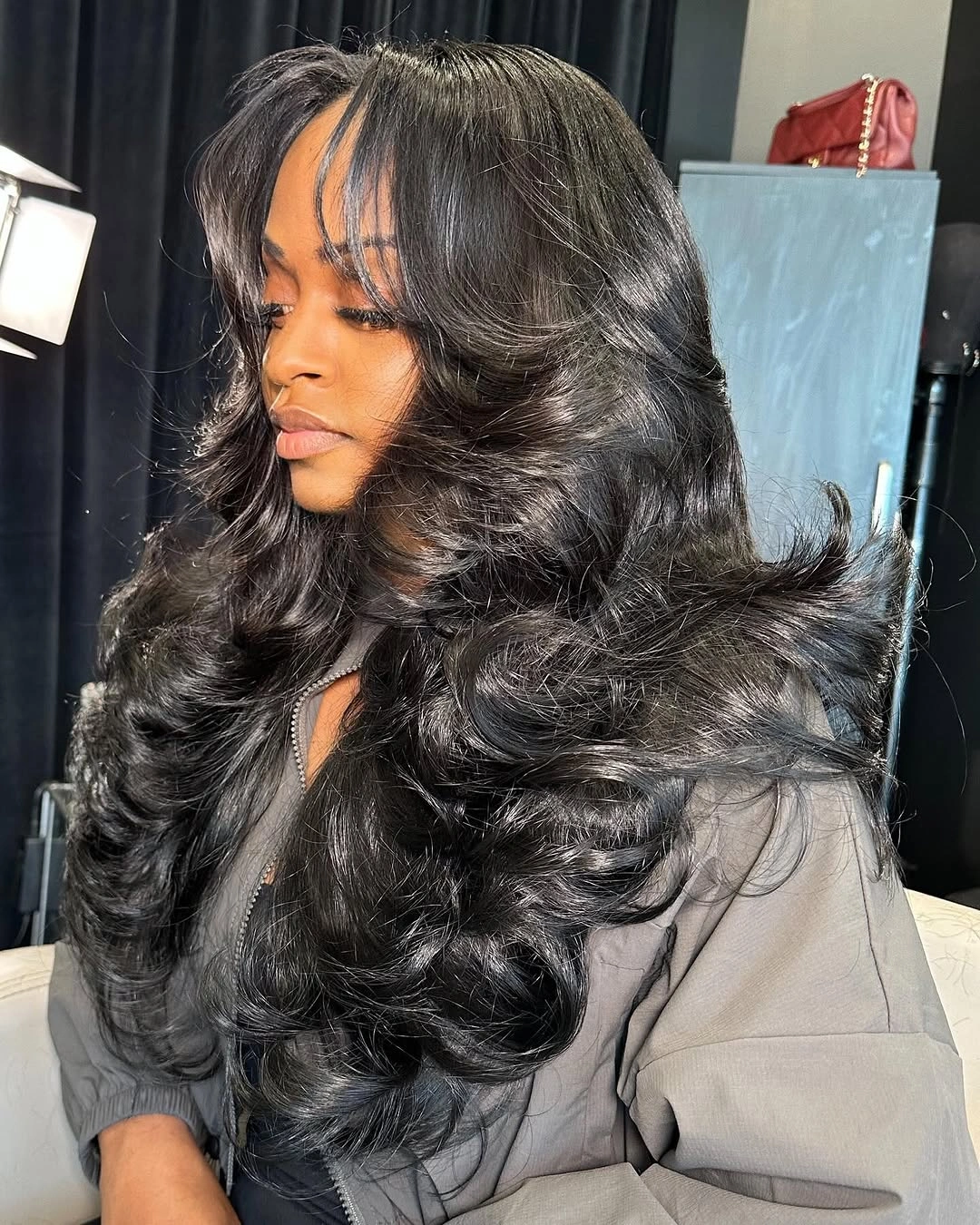 chic middle parting hairstyles - Glossy Black Waves With Feathered Volume