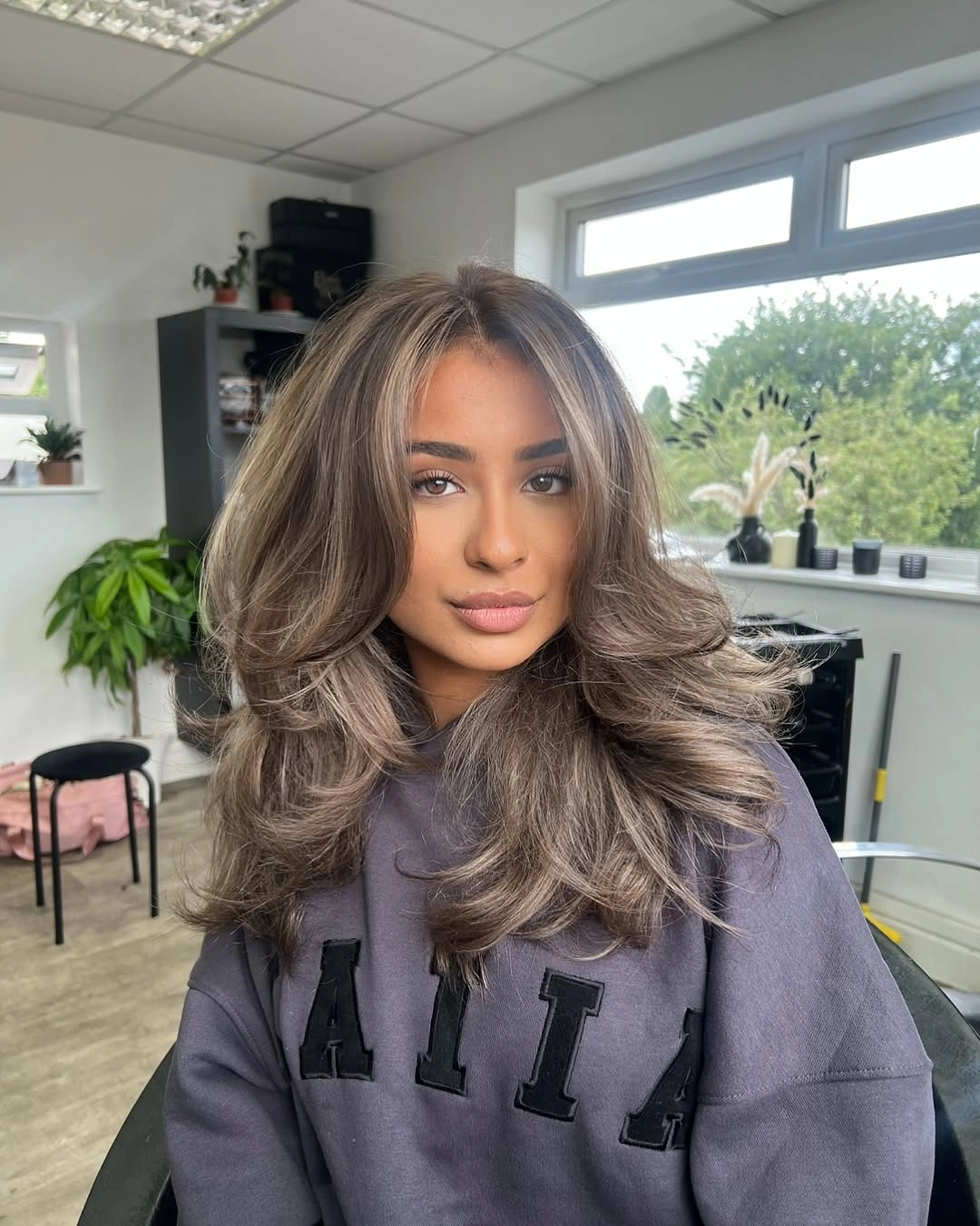 chic middle parting hairstyles - Voluminous brunette layered blowout