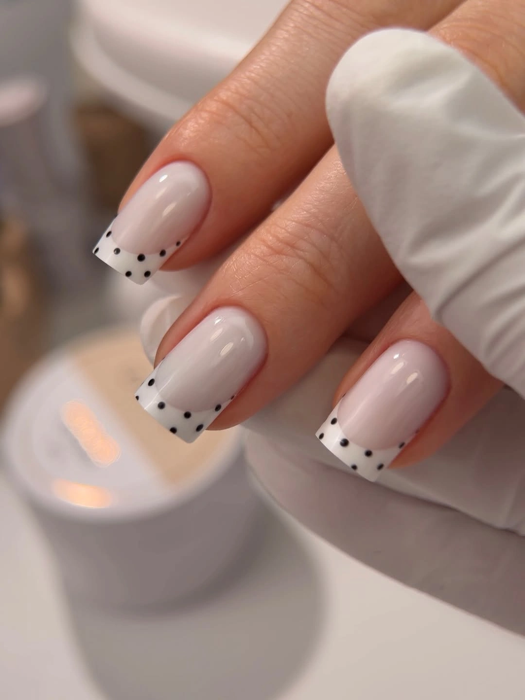 chic polka dot fall nails 2026 minimalist white French tip with black dots