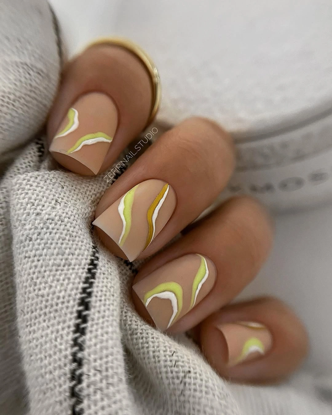 Elegant nude fall nails 2026 with lime green wave design