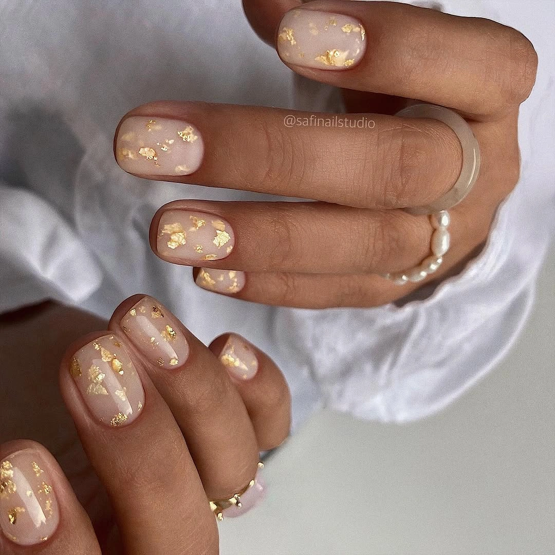 Elegant nude fall nails 2026 with milky nude and gold flakes