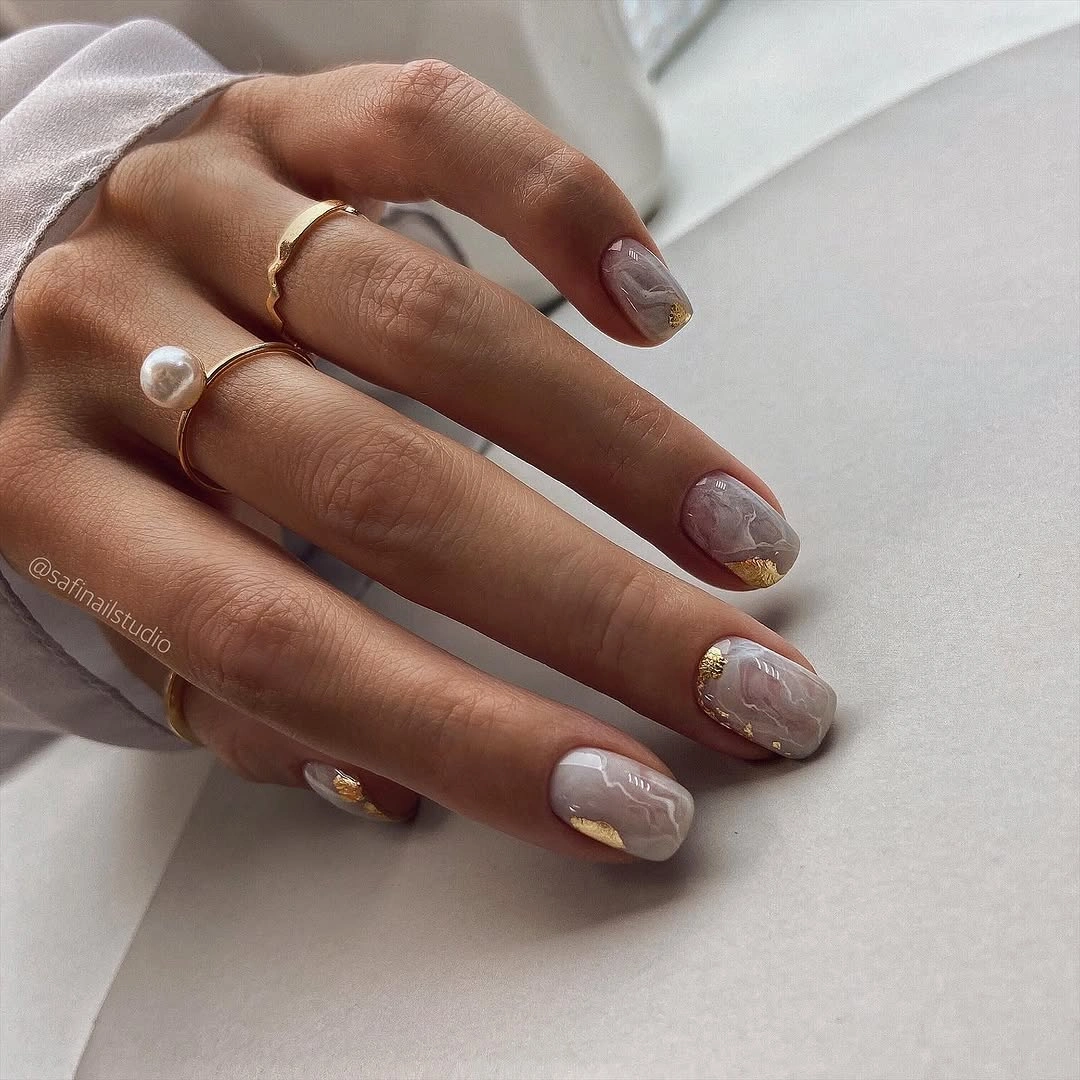 Elegant nude fall nails 2026 with marble almond design and gold accents