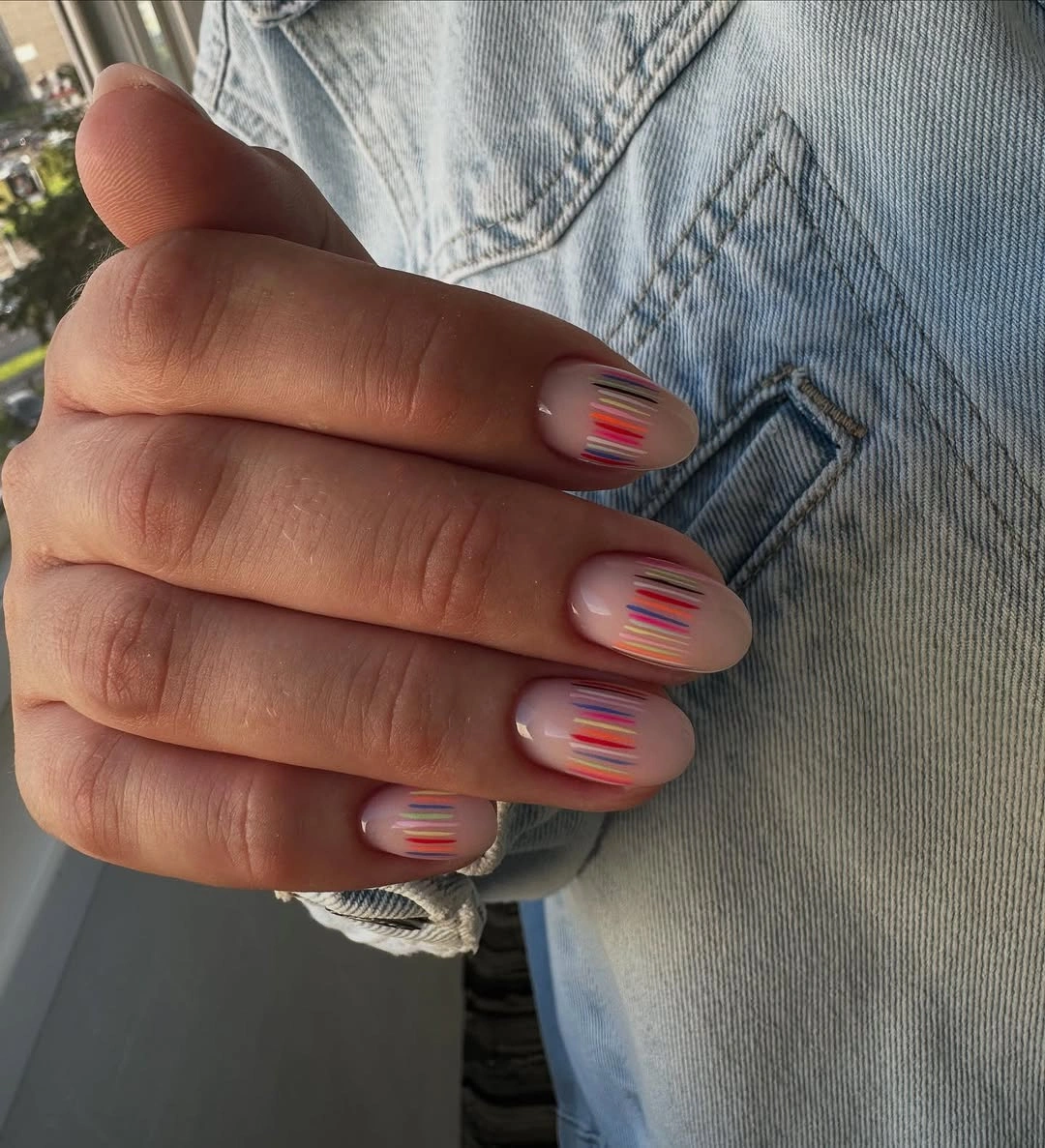 Elegant nude fall nails 2026 with colorful micro-stripe design