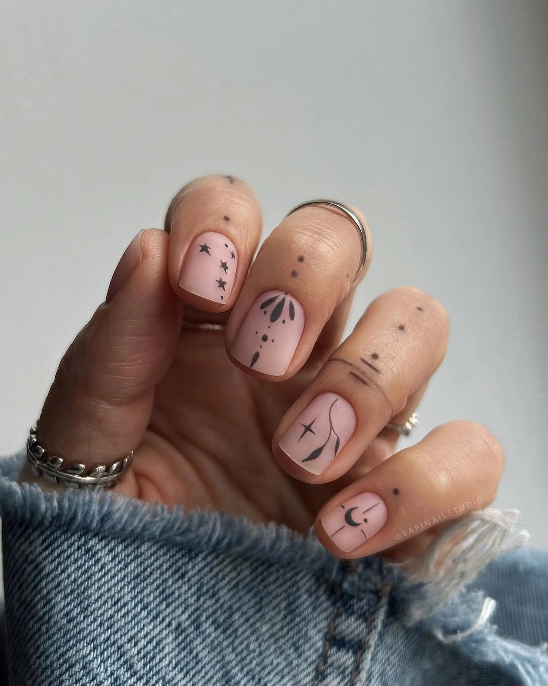 Elegant nude fall nails 2026 with minimal black botanical nail art
