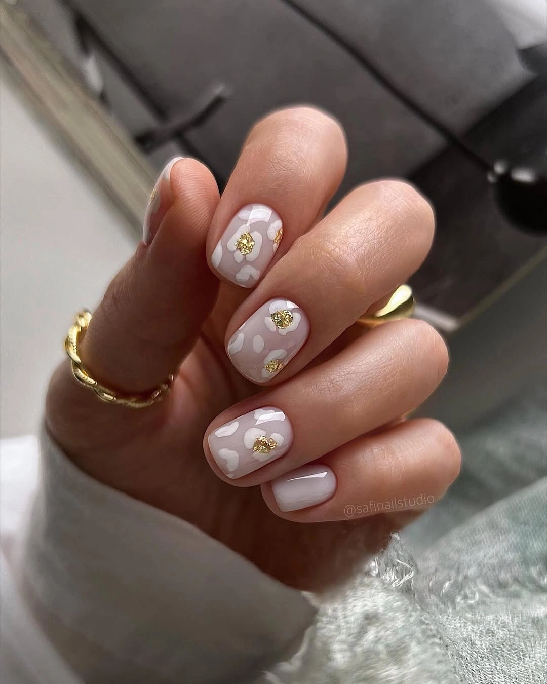Elegant nude fall nails 2026 with gold flower accents