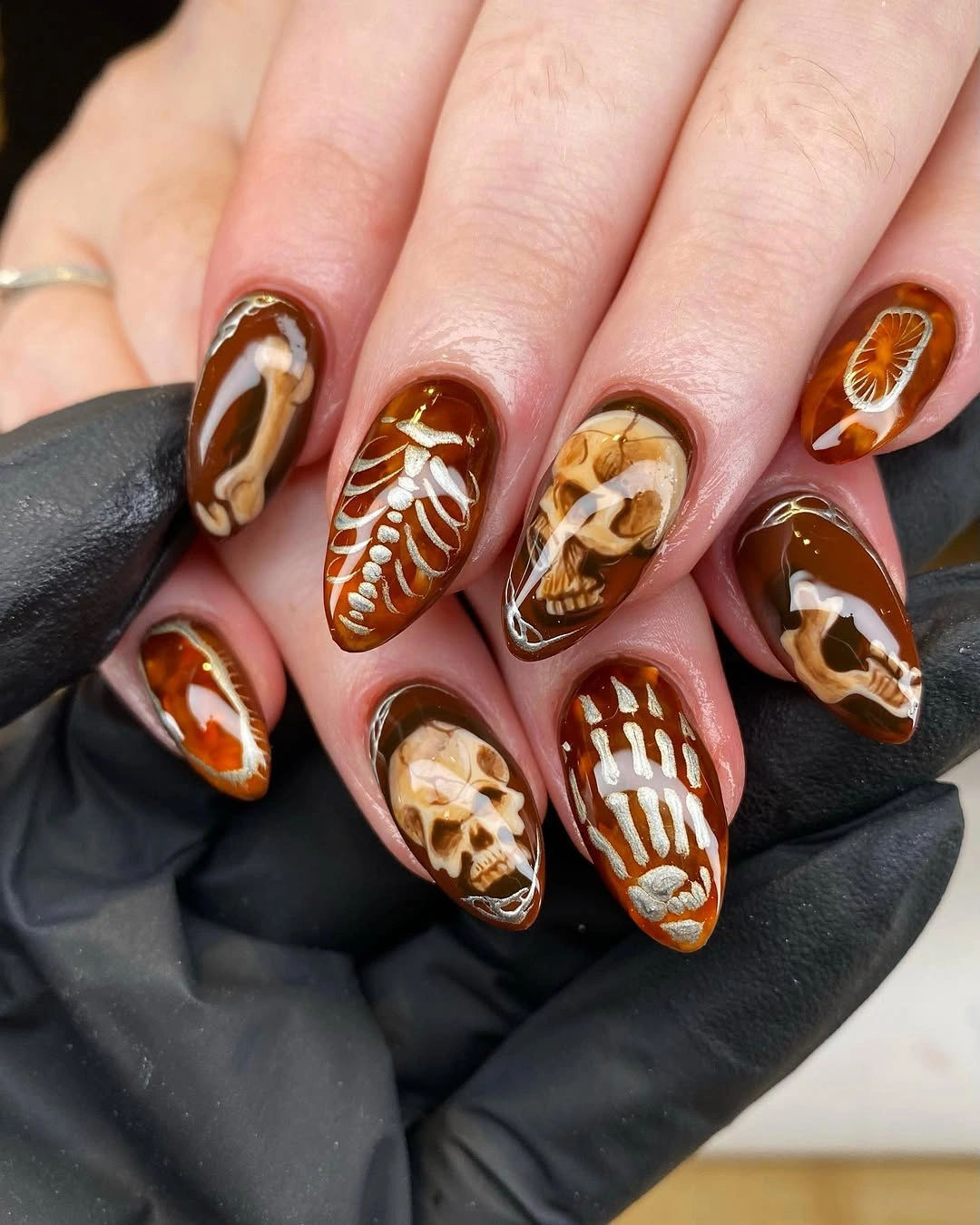 spooky halloween nails designs 2026 amber skeleton bone Halloween almond nails