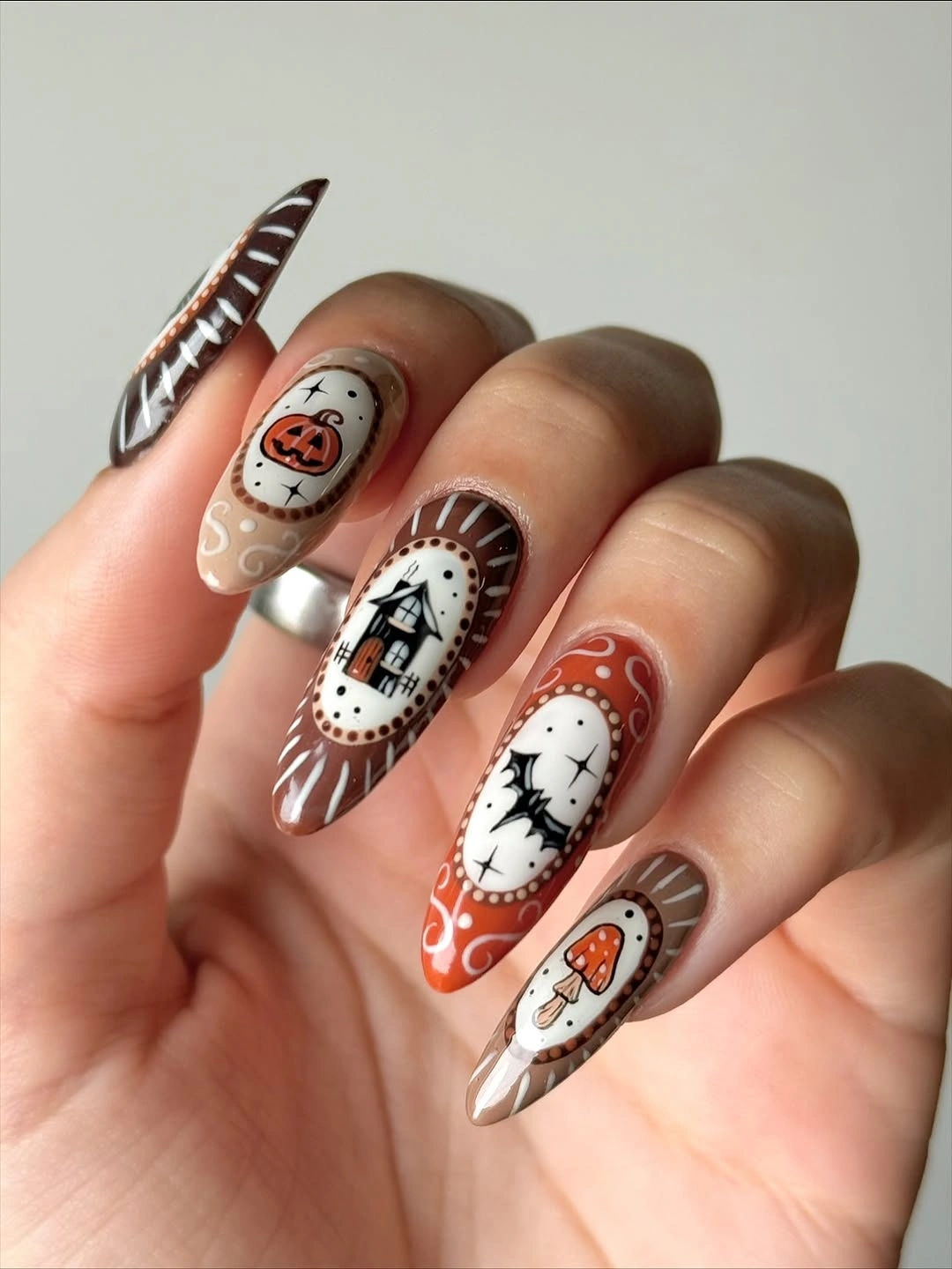 spooky halloween nails designs 2026 orange brown cream Halloween almond nail art