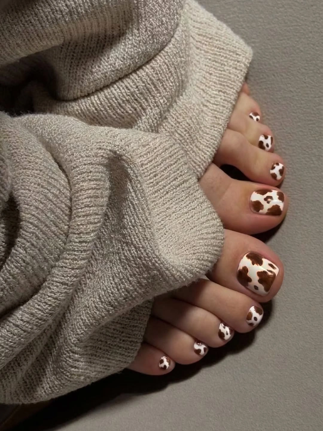 stylish fall toe nails colors 2026 - Brown and White Cow Print for a Cozy Statement
