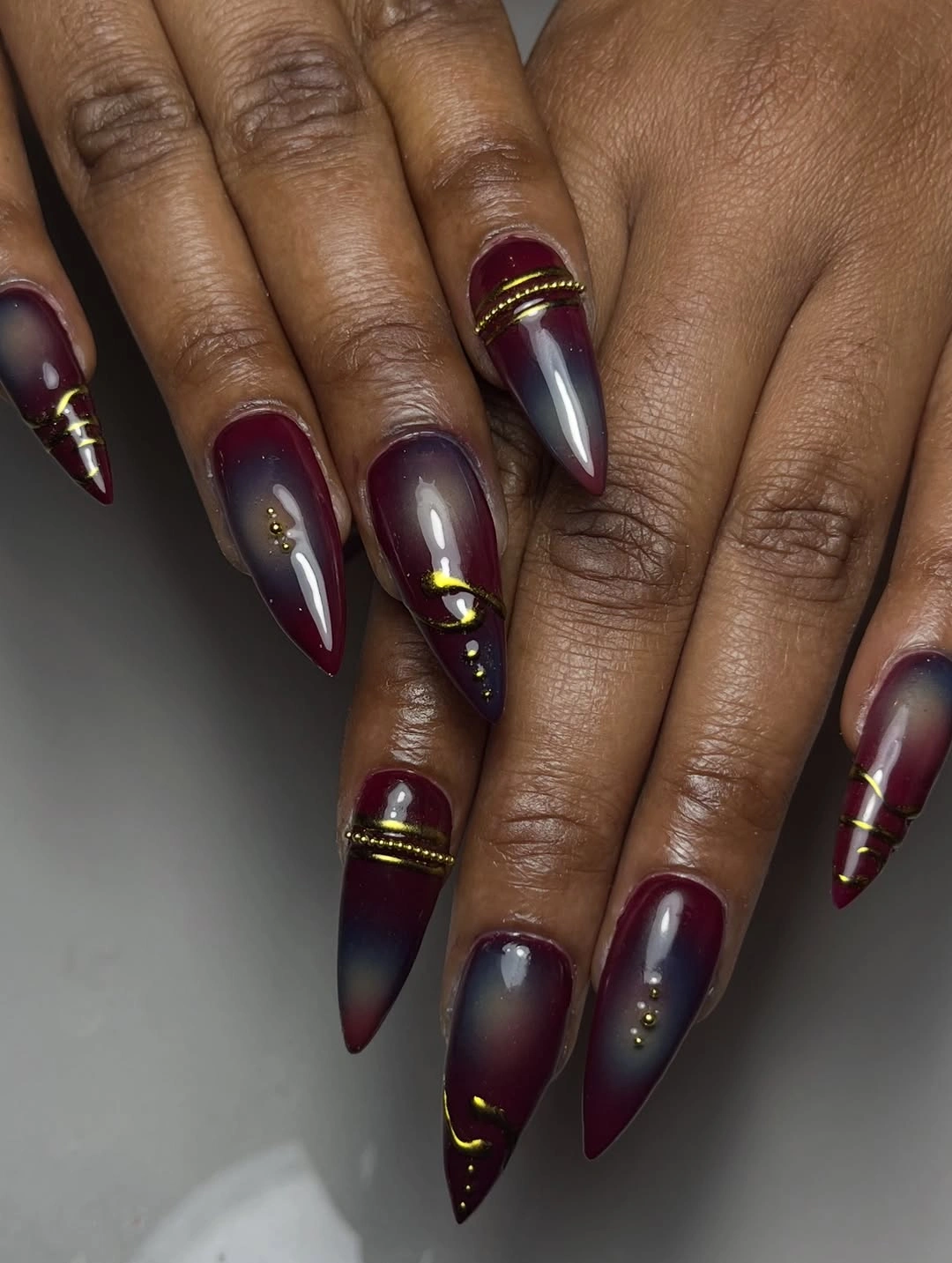 stylish maroon fall nails 2026 Maroon Ombre Nails With Gold Details